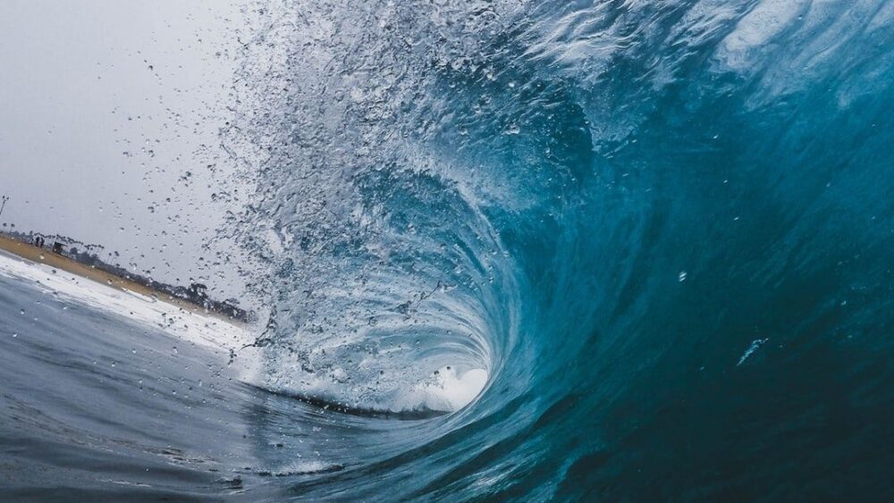 Close-up view inside a curling turquoise ocean wave